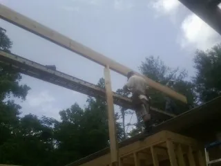 Carpenter setting a ridge beam over a new addition frame — Ice Dam Removal by Roofing Brothers in Ravensdale