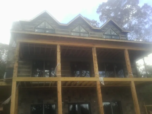 Dormers and porch framing on a large log home under construction — Roof Coating work by our crew in Ravensdale